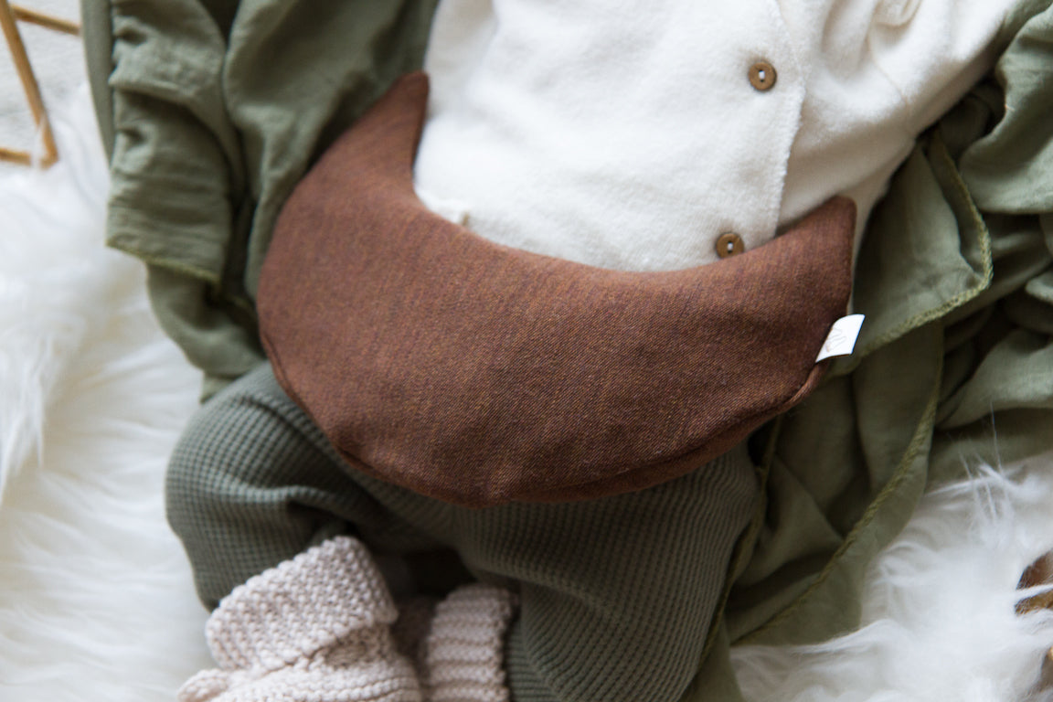 Een handgemaakt maanvormig warmtekussen gevuld met biologisch gereinigde kersenpitten. Het warmtekussen is gemaakt van zachte, duurzame stoffen, waaronder OEKO-TEX en GOTS-gecertificeerd katoen en heerlijk zachte merino wol. Perfect voor het verlichten van buikkrampjes bij baby's, ondersteuning bij borstvoeding en ontspanning voor mama. Verkrijgbaar in verschillende stijlvolle prints.