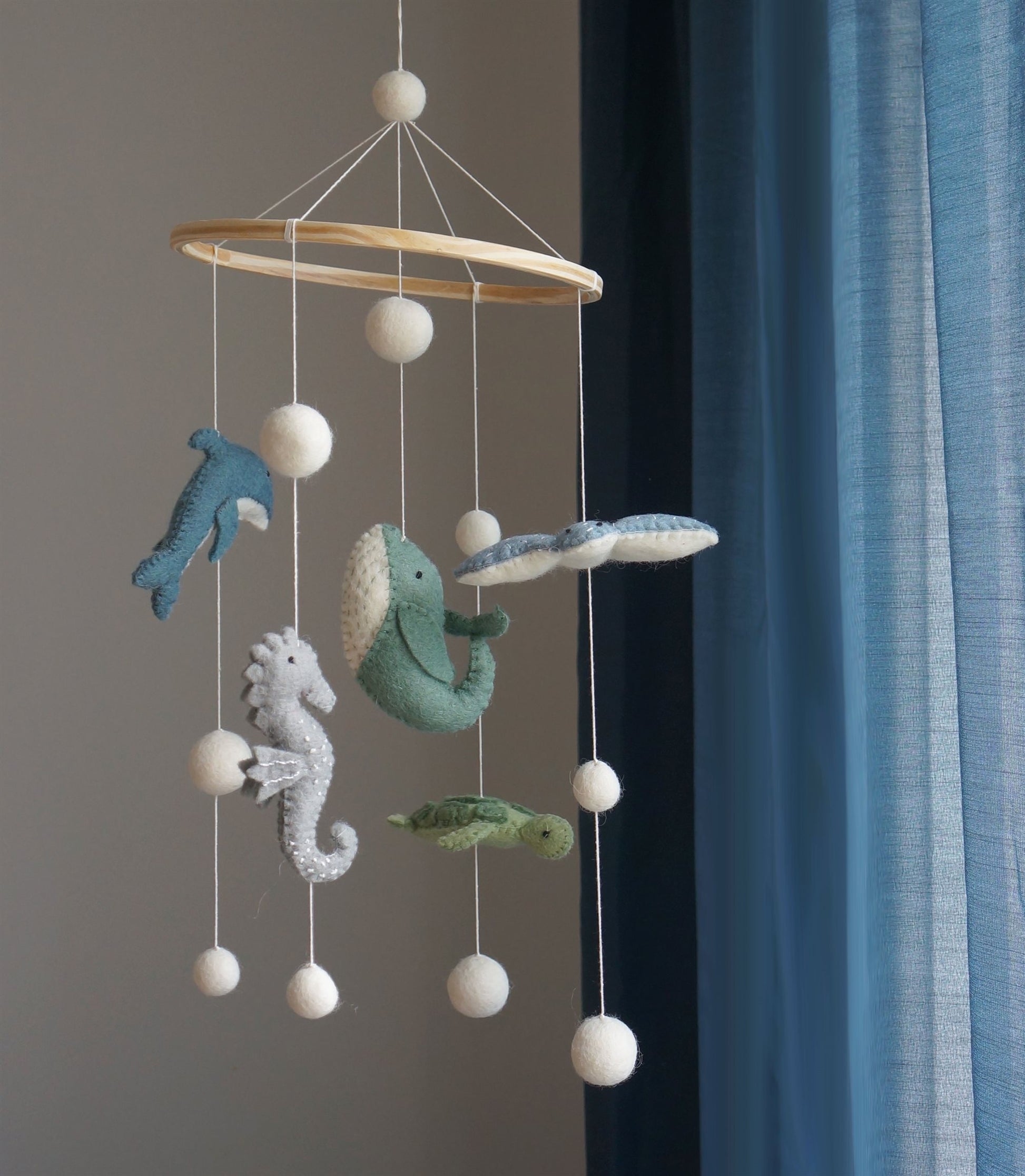 Handgemaakte Gamcha wiegmobiel van 100% wolvilt, fair trade geproduceerd in Nepal – perfect als rustgevende en natuurlijke decoratie voor de babykamer.