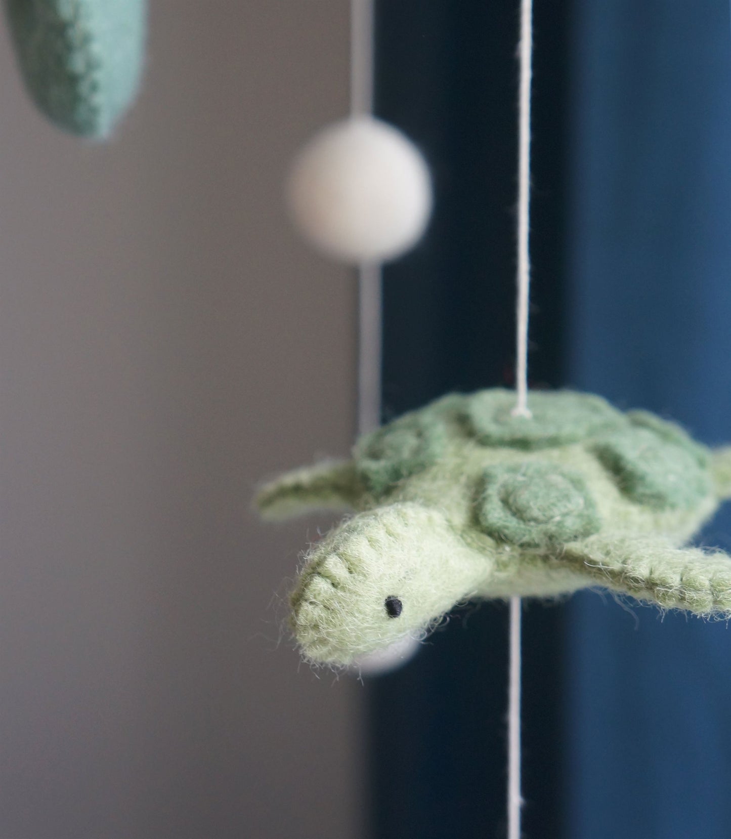 Handgemaakte Gamcha wiegmobiel van 100% wolvilt, fair trade geproduceerd in Nepal – perfect als rustgevende en natuurlijke decoratie voor de babykamer.