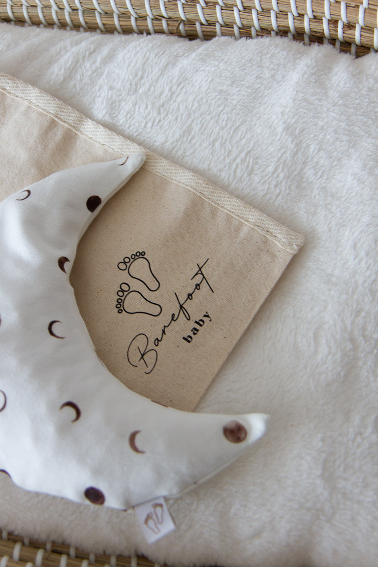 Een handgemaakt maanvormig warmtekussen gevuld met biologisch gereinigde kersenpitten. Het warmtekussen is gemaakt van zachte, duurzame stoffen, waaronder OEKO-TEX en GOTS-gecertificeerd katoen en heerlijk zachte merino wol. Perfect voor het verlichten van buikkrampjes bij baby's, ondersteuning bij borstvoeding en ontspanning voor mama. Verkrijgbaar in verschillende stijlvolle prints.