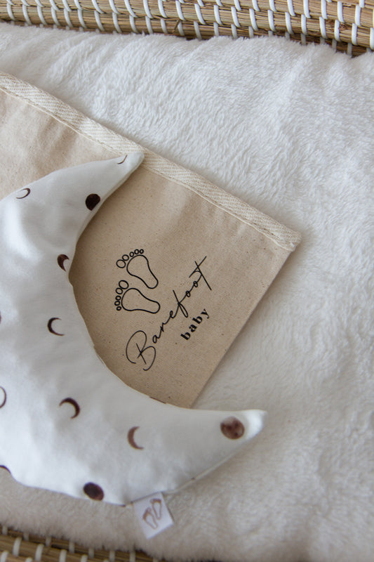 Een handgemaakt maanvormig warmtekussen gevuld met biologisch gereinigde kersenpitten. Het warmtekussen is gemaakt van zachte, duurzame stoffen, waaronder OEKO-TEX en GOTS-gecertificeerd katoen en heerlijk zachte merino wol. Perfect voor het verlichten van buikkrampjes bij baby's, ondersteuning bij borstvoeding en ontspanning voor mama. Verkrijgbaar in verschillende stijlvolle prints.