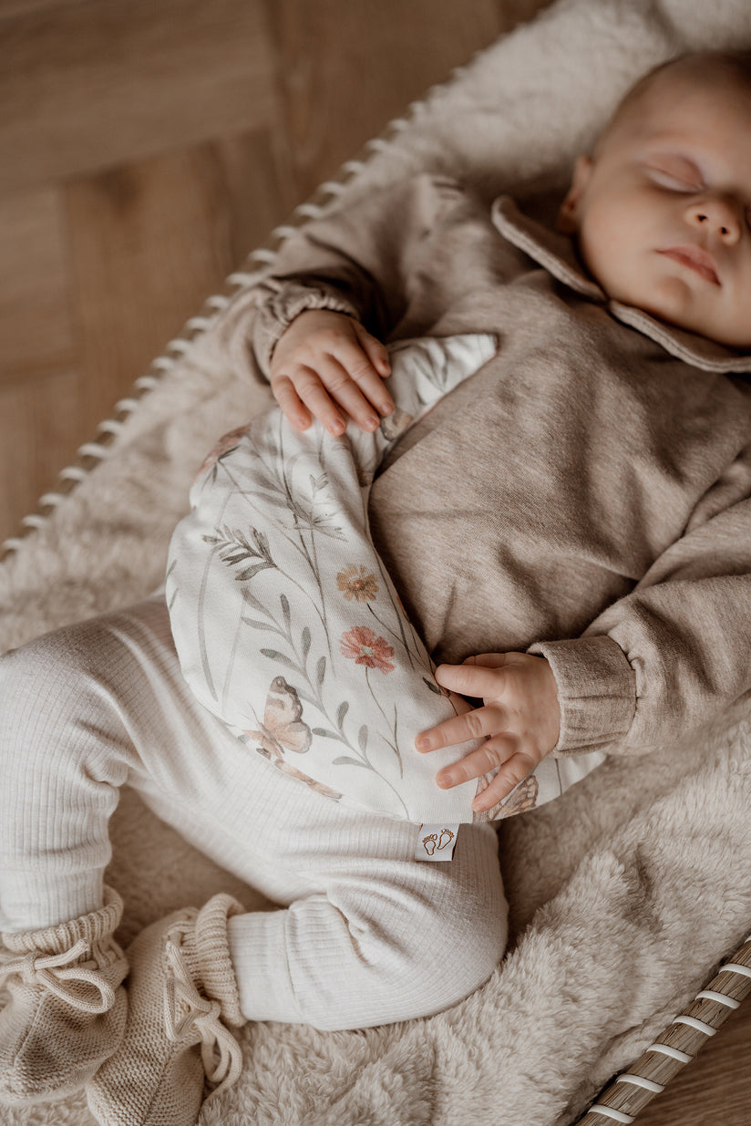 Een handgemaakt maanvormig warmtekussen gevuld met biologisch gereinigde kersenpitten. Het warmtekussen is gemaakt van zachte, duurzame stoffen, waaronder OEKO-TEX en GOTS-gecertificeerd katoen en heerlijk zachte merino wol. Perfect voor het verlichten van buikkrampjes bij baby's, ondersteuning bij borstvoeding en ontspanning voor mama. Verkrijgbaar in verschillende stijlvolle prints.